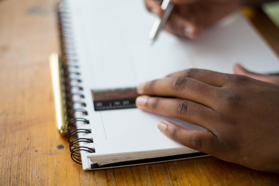 Hand die schrijft in een schrift