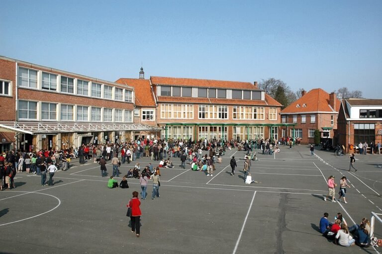 Speelplaats met spelende kinderen voor het schoolgebouw