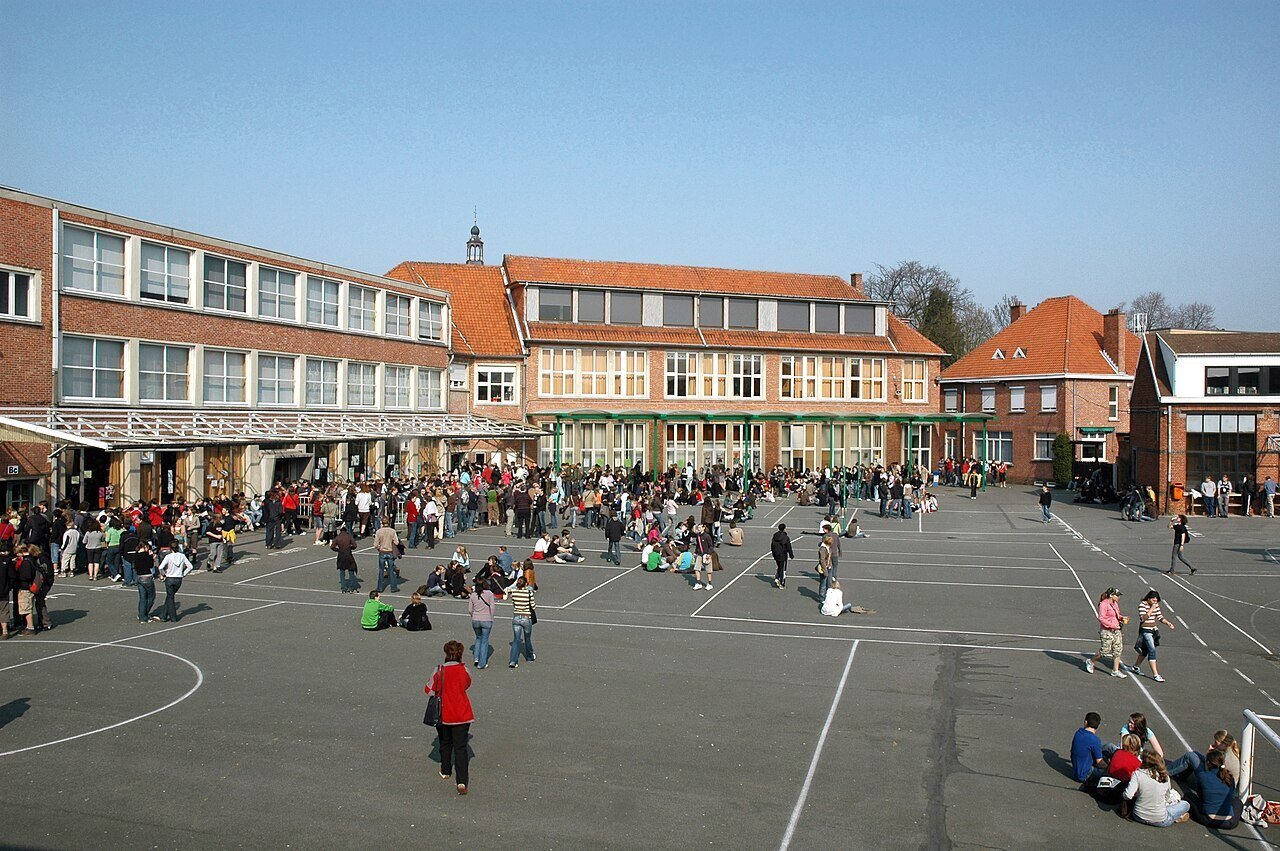 Speelplaats met spelende kinderen voor het schoolgebouw